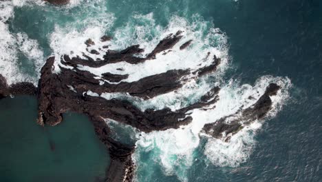 aerial topdown of waves hitting rocks on coasltine, madiera, portugal