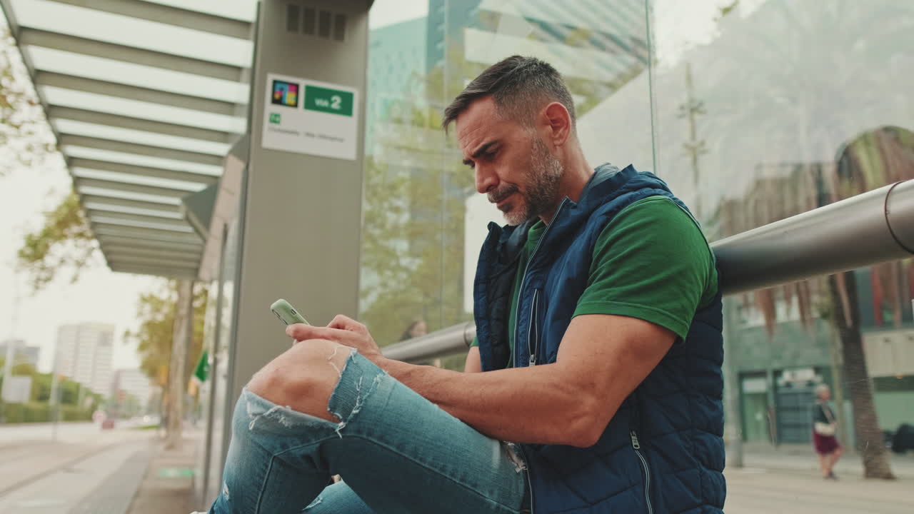 Uomo seduto a una fermata dell'autobus