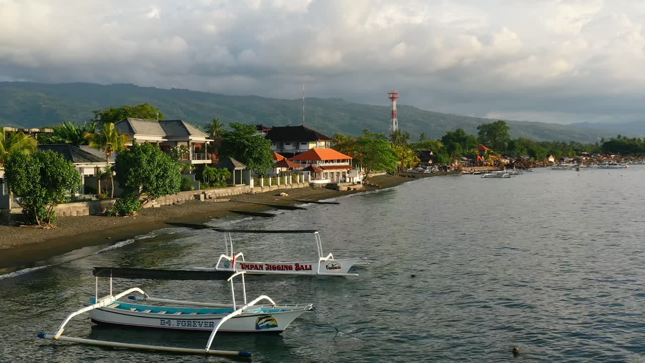 황금시간대 일몰 동안 발리 인도네시아의 로비나 해변에서 잔잔한 열대 바다의 공중 해안선
