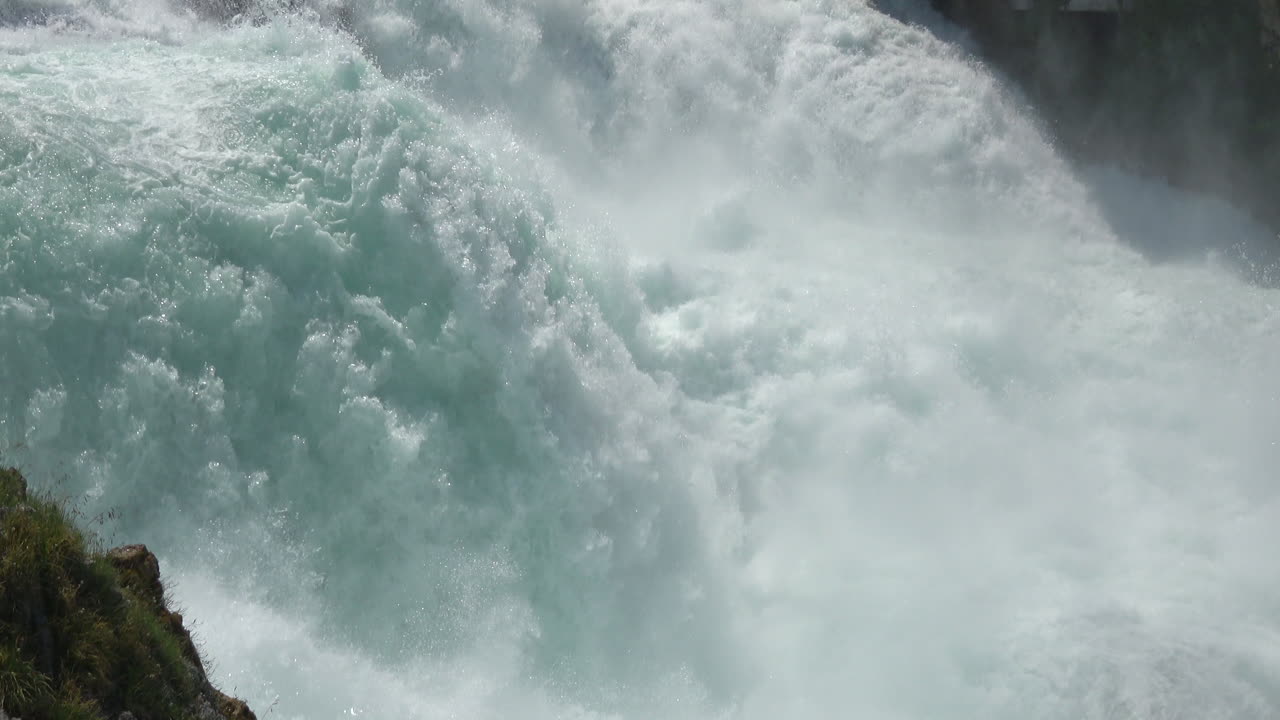 Nærbilledoptagelse af Rhinfaldene med turbulent turkisblåt vand og vandsprøjt, et berømt naturlandemærke nær Schaffhausen, kantonen Schaffhausen, Schweiz.