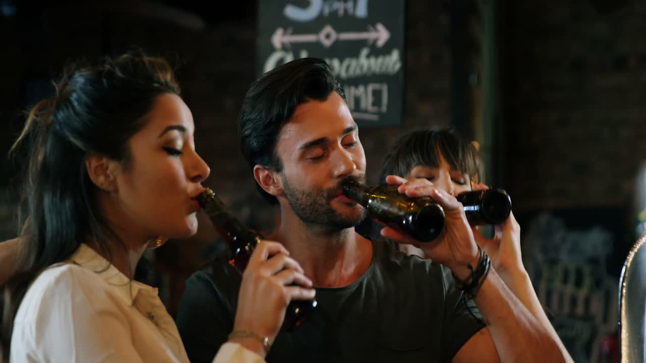 un gruppo di amici che interagiscono mentre brindano a bottiglie di birra