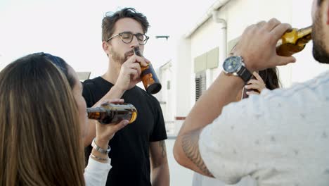 Joyful-friends-drinking-beer-on-balcony