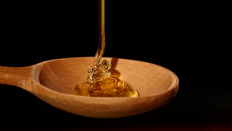 honey pouring into a wooden spoon