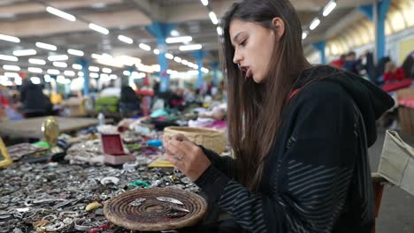 woman browsing jewelry at flea market