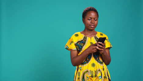 Native-girl-in-ethnic-outfit-browsing-internet-webpages-in-studio