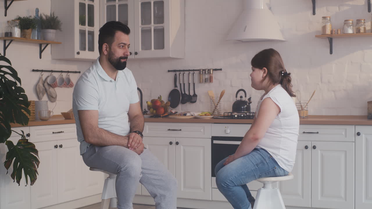 Father and Daughter Talking in Kitchen