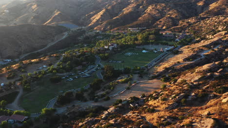 spectacular aerial drone flying towards a beautiful wedding venue situated between amazing rocky mountains in california during an incredible sunset