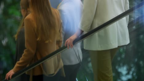 business people moving down on escalator in the office 4k