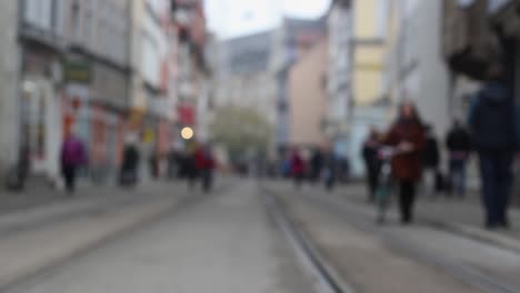 blurry people moving in downtown erfurt, historic city in germany