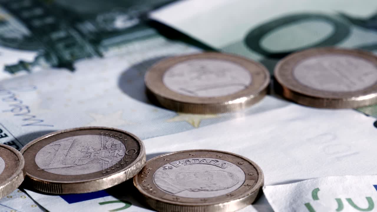las monedas en euros que caen sobre los billetes en euros