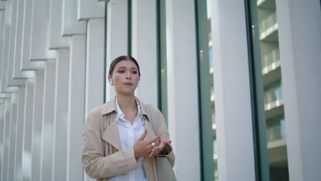 Woman-calling-phone-earbuds-walking-on-city-street-closeup.-Lady-speaking-mobile