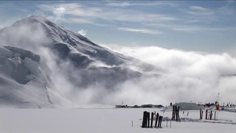 Skis-in-the-snow-as-the-wind-blows-over-peak