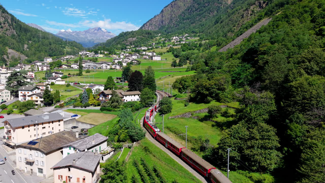 Scenic red train travels through Swiss mountains, offering a serene journey