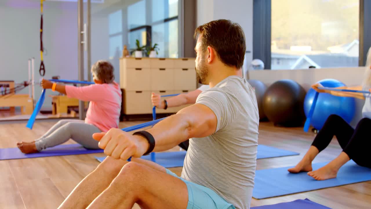 entrenador ayudando a las mujeres mayores en la realización de yoga 4k