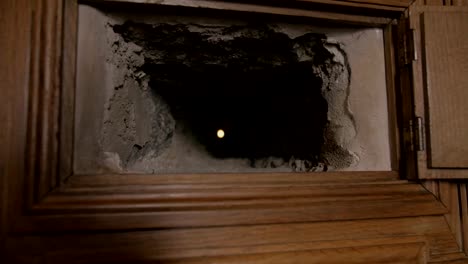 tiny spy hole with wooden frame in medieval castle wall, zoom out shot