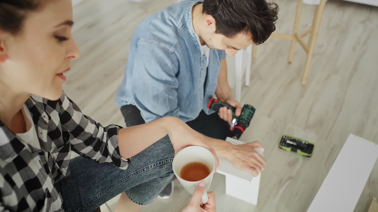 video de mano de la discusión de la pareja mientras se instala la estantería.