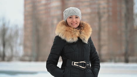 Hembra-Madura-Mirando-A-La-Cámara-En-Ropa-De-Invierno-Con-Un-Gorro-De-Lana-Al-Aire-Libre