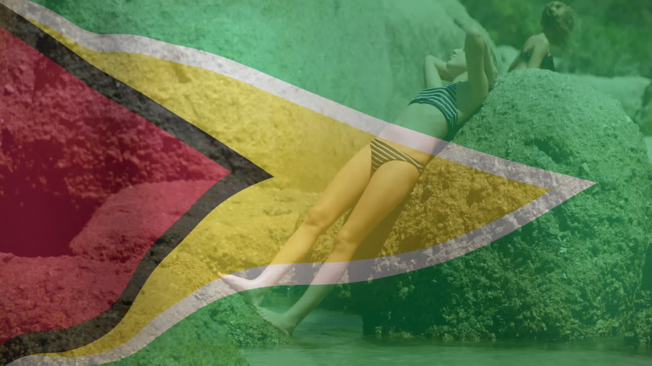 Relaxing in swimwear on rocks, person with animation of Guyana flag overlay