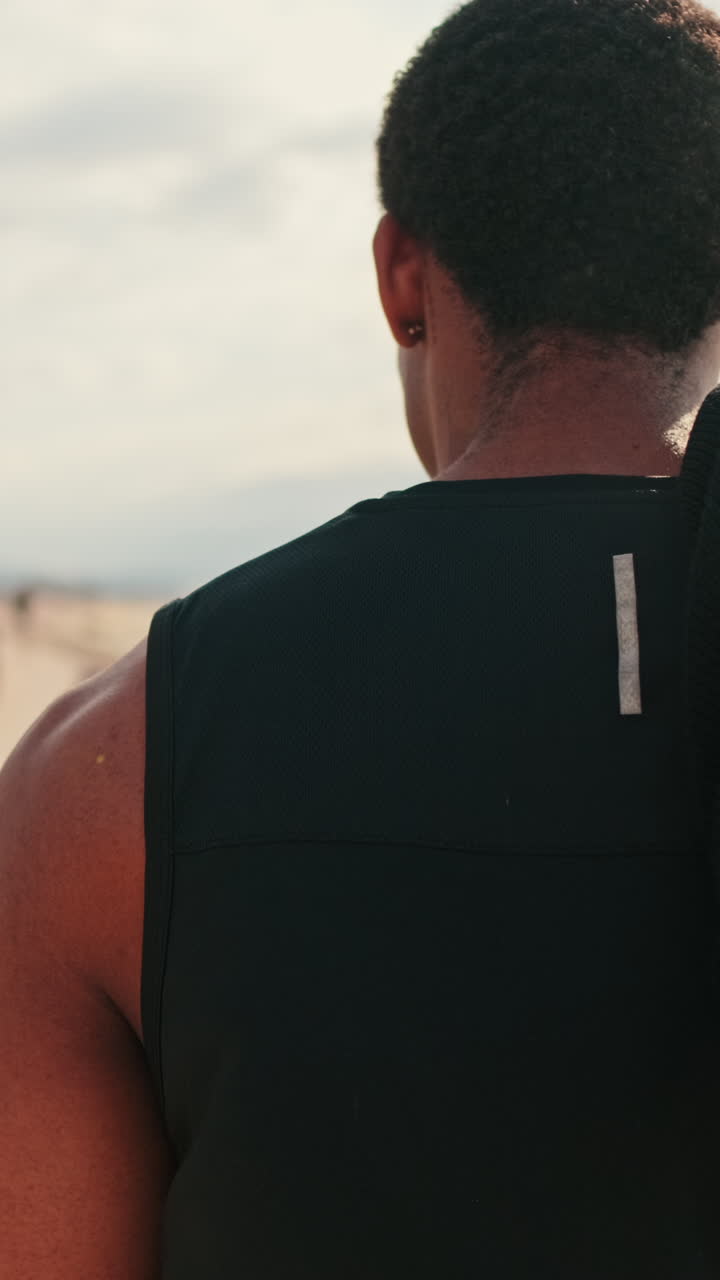 Muscular Man Walks on a Sunny Beach