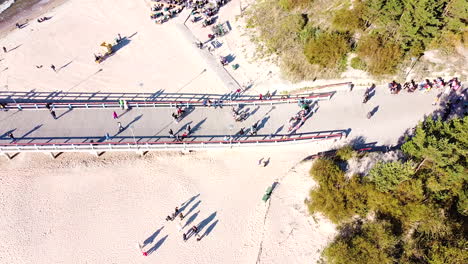 people walk on palanga bridge on sunny day, aerial static view