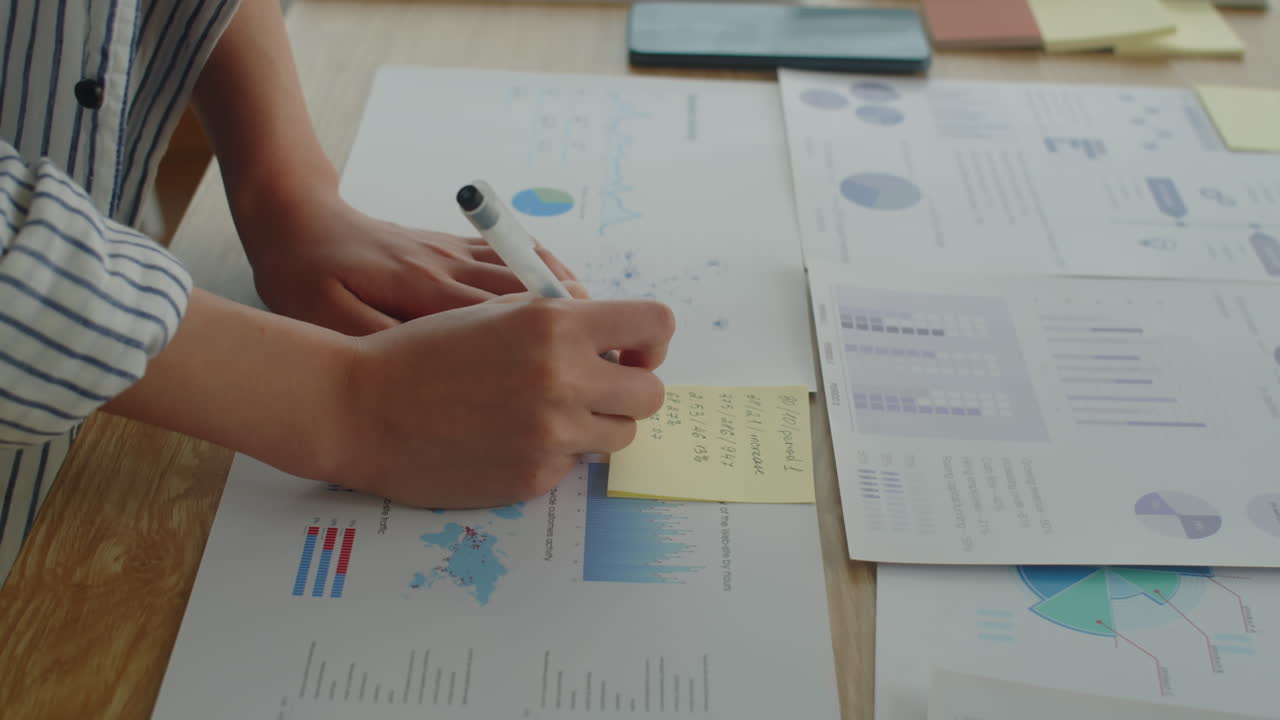 Female Analyst Compiling Business Statistics on Paper