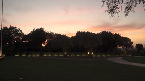 static shot at sunset of golf court surrounded with green trees, cadiz, spain