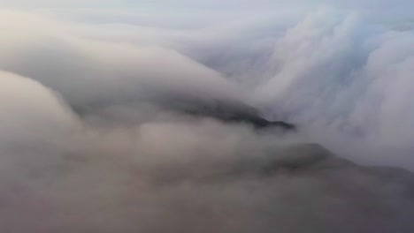 Massive-clouds-moving-around-mountain-peak-Tai-Mo-Shan,-Hong-Kong