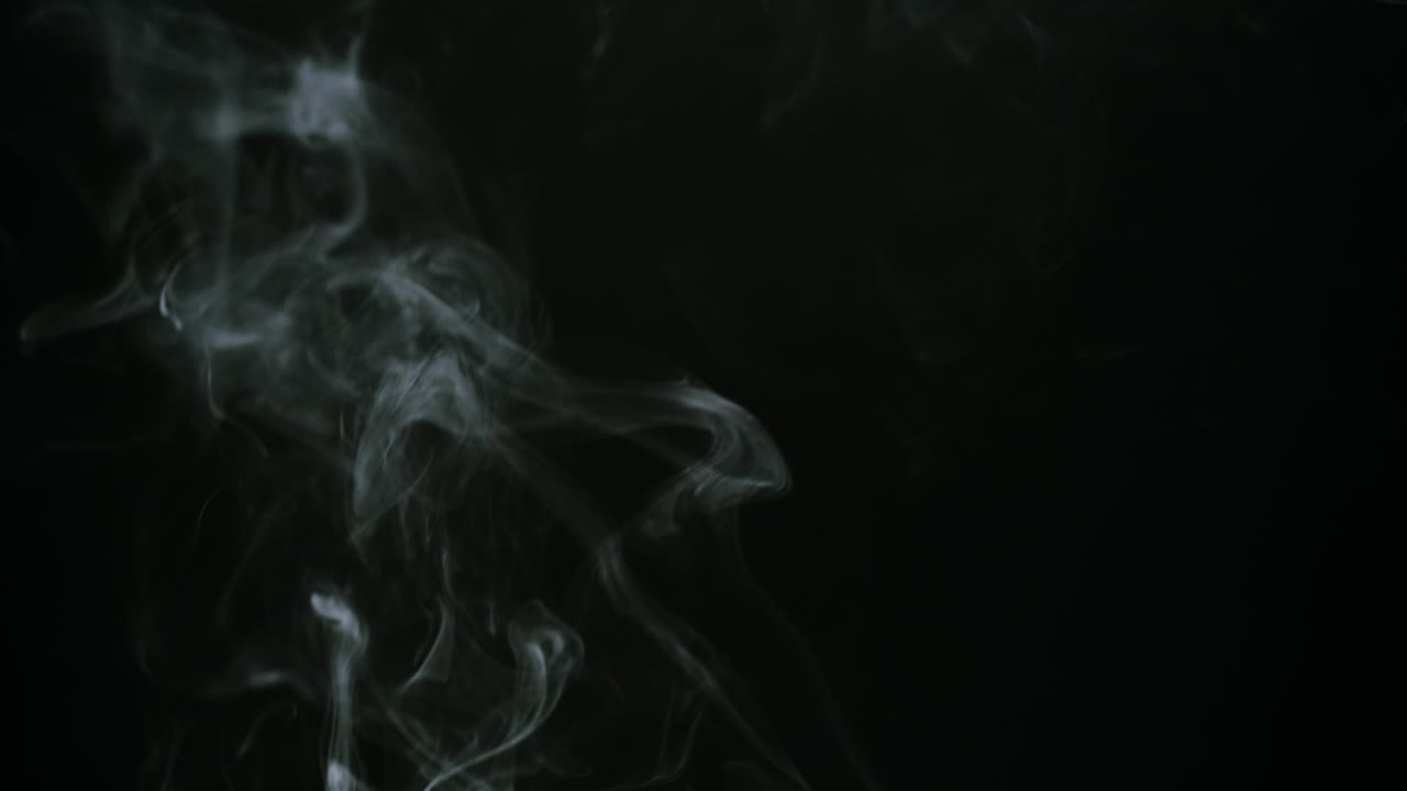 Wispy White Smoke Flowing Against a Black Background