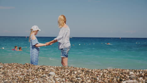 mom and daughter are having fun in surf waves on the sea happy moments with children slow motion vid