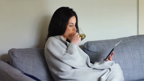 woman using digital tablet while having green tea 4k