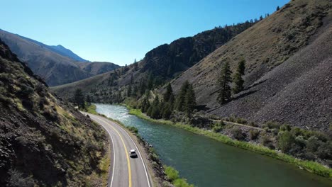 car driving road along snake river in idaho- aerial follow behind