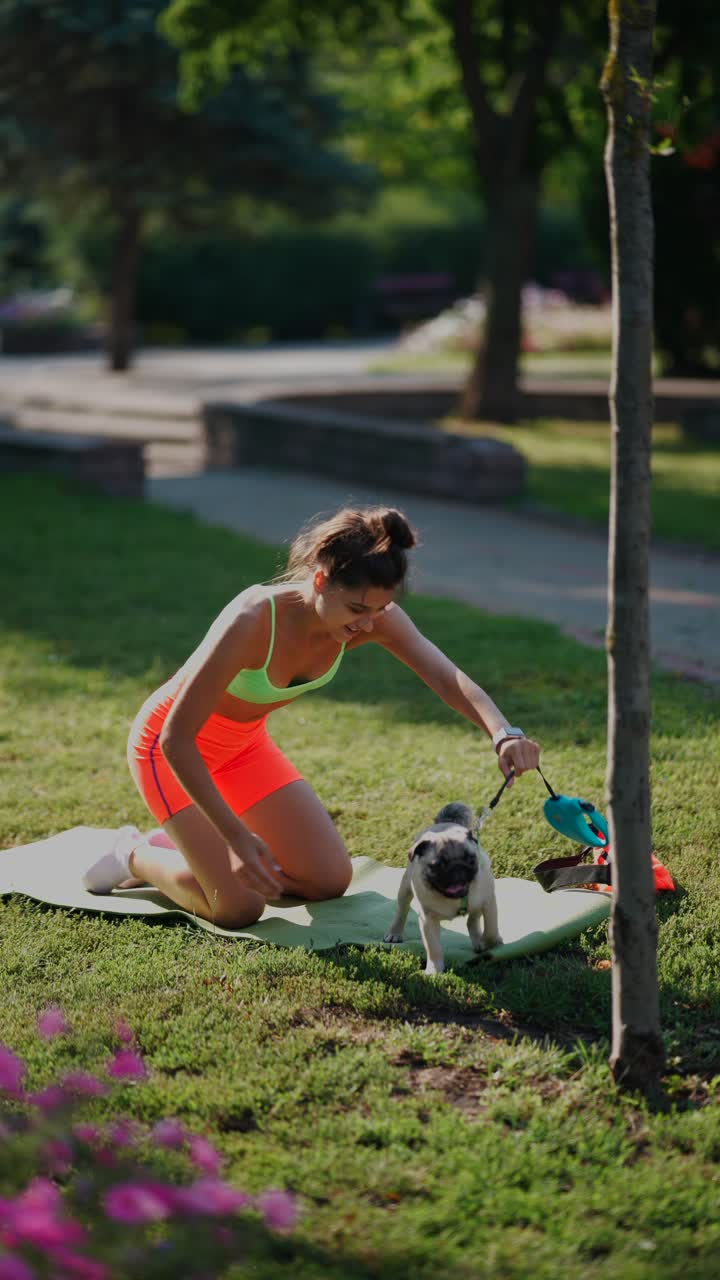 mujer practicando yoga con su pug en el parque