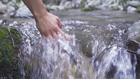 Put one&#039;s hand in the stream. Slow motion.