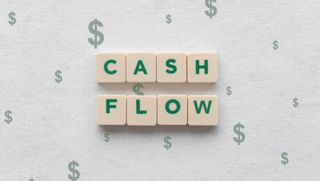 green dollar signs going up behind the cash flow shown on scrabble blocks