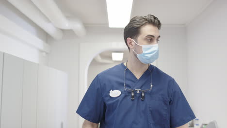 tracking shot of a dentist or surgeon walking through a medical centre, long day