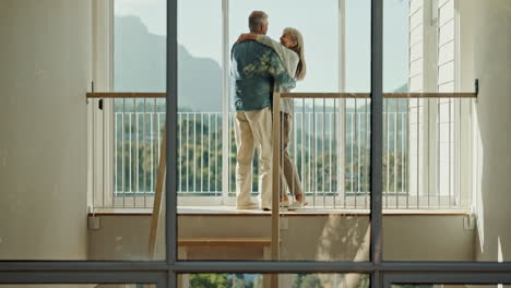 mature couple embracing with love and joy in their home with a beautiful view