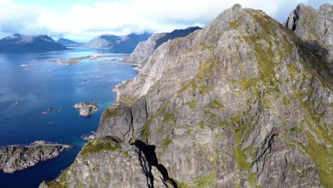 Volando-Sobre-Las-Altas-Montañas-De-Las-Islas-Lofoten-En-El-Norte-De-Noruega-Con-Vistas-A-Los-Picos-De-Las-Montañas-Y-Al-Mar-Con-Sus-Numerosas-Islas-Pequeñas-Y-Las-Rutas-De-Senderismo-Que-Suben-A-La-Montaña