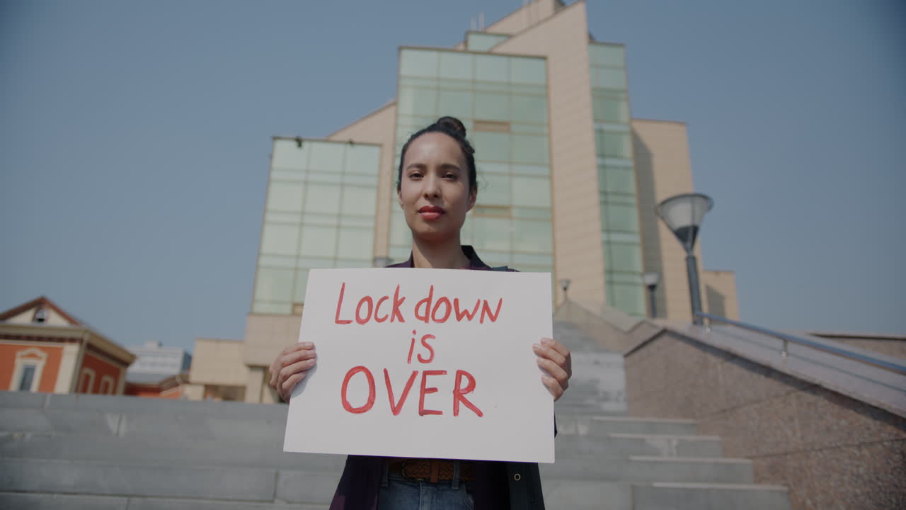 Woman Holding Sign Saying 'Lockdown is Over'