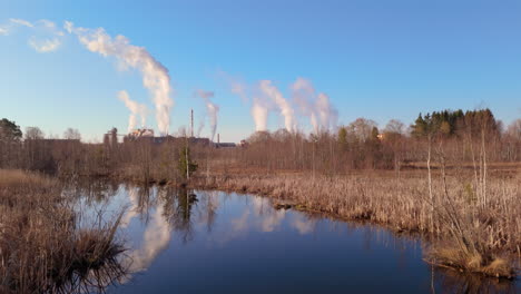 vista del avión no tripulado sobre el río con el reflejo de los gases de efecto invernadero emitidos por la fábrica