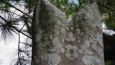 Magnífico-Primer-Plano-En-Cámara-Lenta-De-Un-Vestido-De-Novia-De-Diseñador-Colgado-De-Un-árbol-En-El-Patio