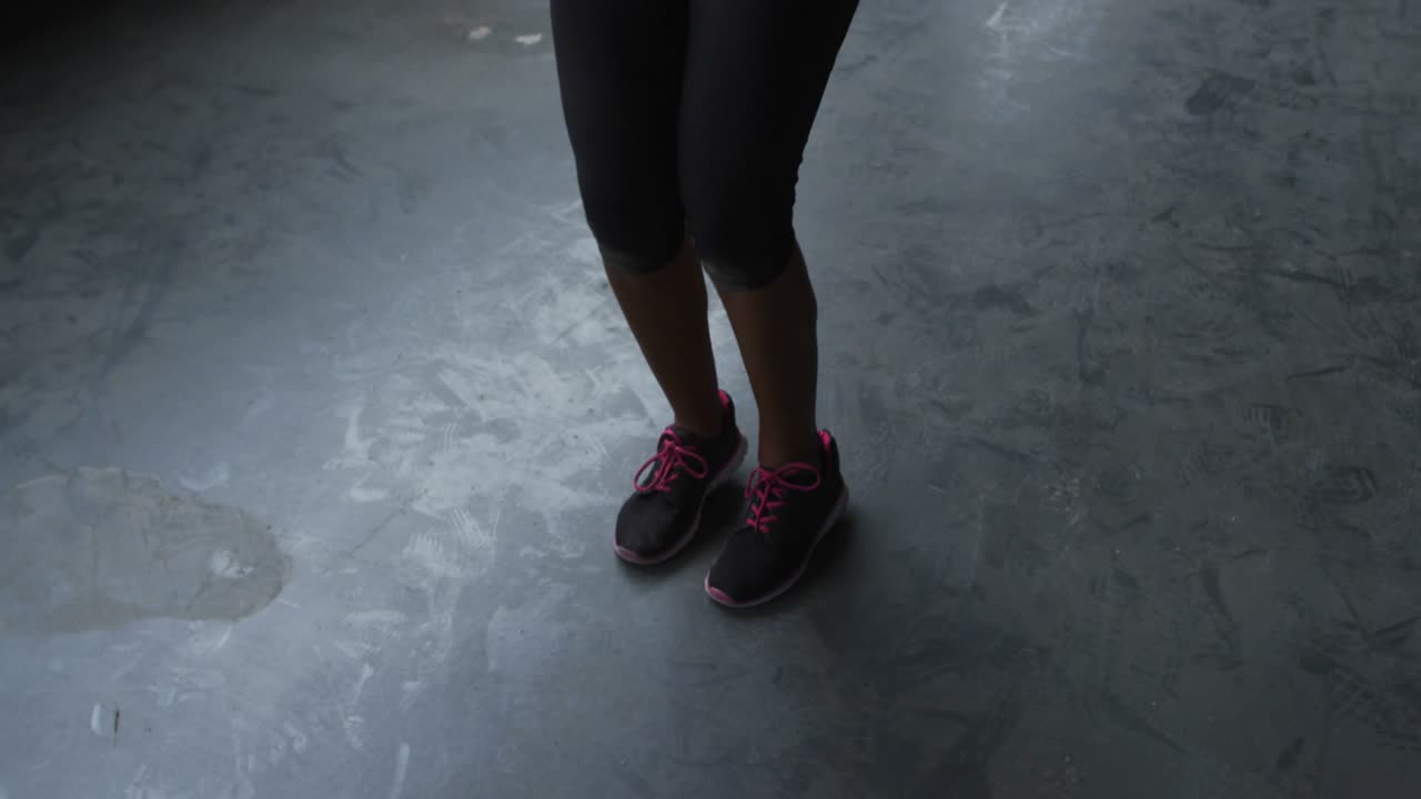 Female skipping rope on worn floor, glitch morphing into YOU WIN! overlay over subject for workout