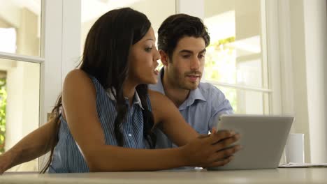 pareja interactuando entre sí mientras usan una tableta digital