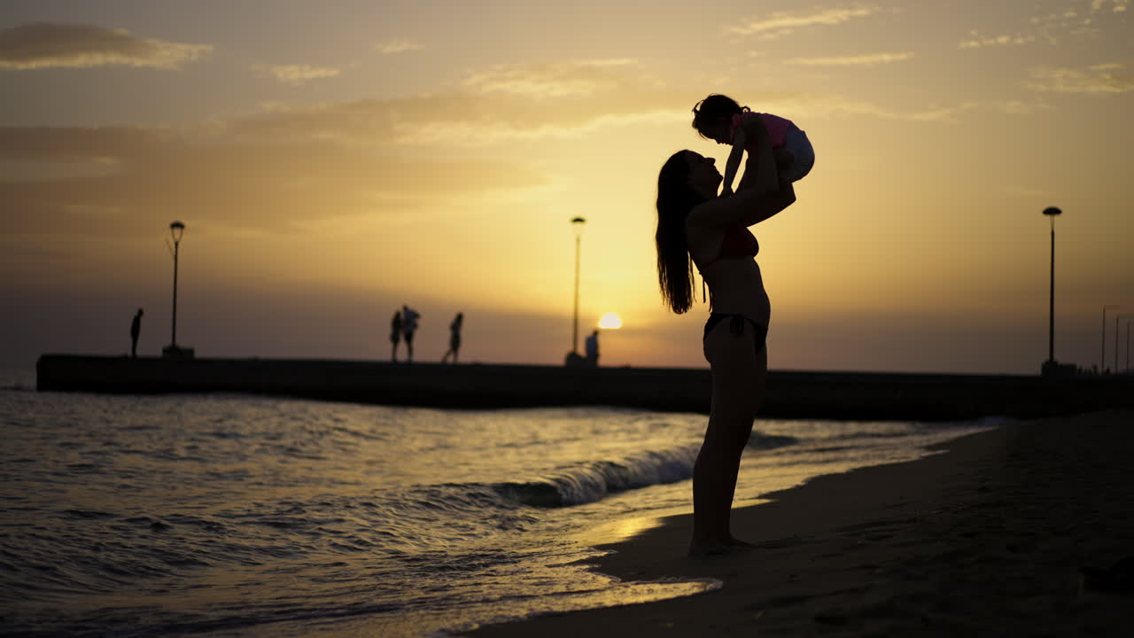 Mother and child enjoying a sunset at the beach