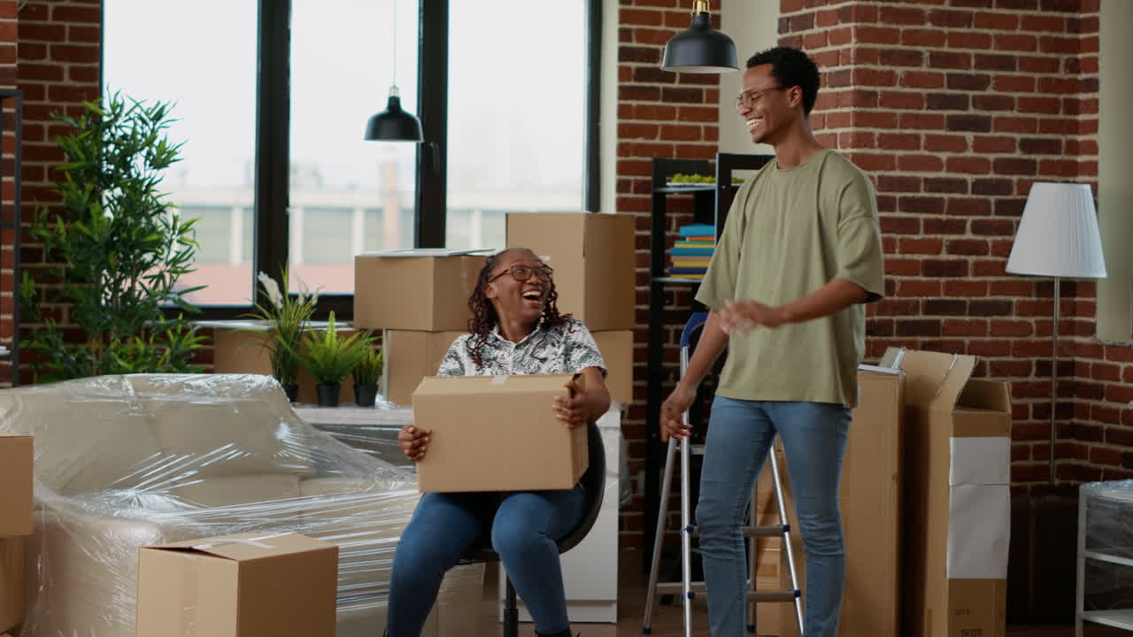 Married couple decorating living room apartment and having fun