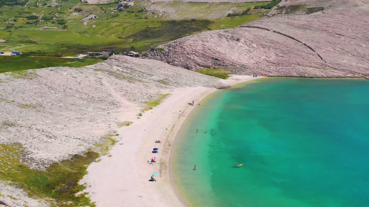 크르크, 크로아티아의 한적한 해변을 즐기는 사람들 위의 높은 공중 비행