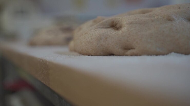 large dough lies on a wooden board for baking in flour