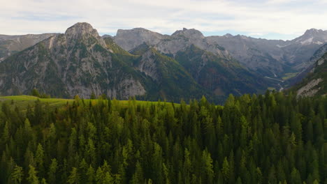 Aerial-view-rising-over-protected-Pertisau-alpine-woodland-hillside-towards-Austrian-Tyrol-mountains