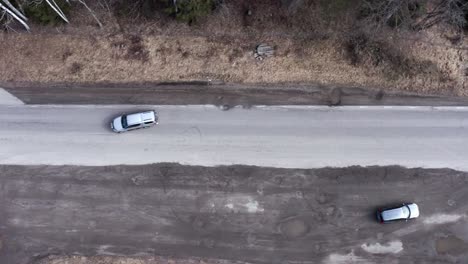 top down drone shot of small asphalt road exit next to forest in sweden