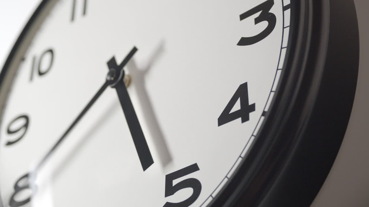 el reloj blanco se acerca en el lapso de tiempo en la pared blanca
