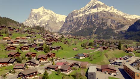 aerial drone footage flying over grindelwald grund in front of majestic wetterhorn mountain in the swiss alps